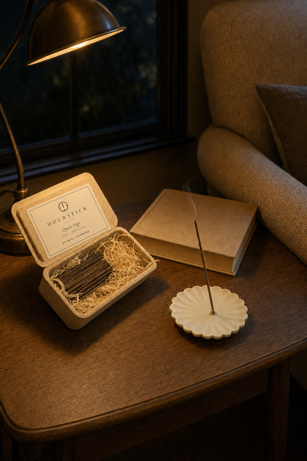 Quiet Page incense box with scent label open beside a book under a warm reading lamp at night