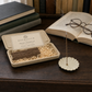 Scholar's Sandalwood incense box with scent label in a dark walnut study, stick burning in ceramic holder